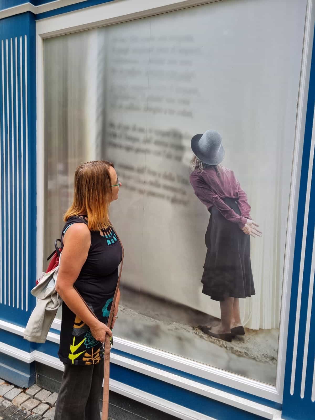 Mandy die aandachtig naar een levensgrootte affiche kijkt van een meisje die staande in een supergroot boek kijkt